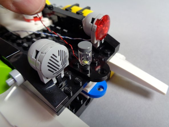 Place the cool white Pico LED with the LED side facing up in the center of these four studs, so neither the LED nor the wire touches any of the surrounding studs.