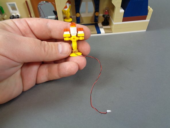 As shown in the first photo for this step, a pre-lit candelabra will be inside the Interior Lights box, and you will use this to replace the unlit one in your Disney Castle.