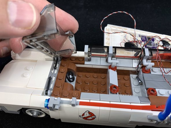 As shown in the three photos for this step, remove parts to make room for installing the searchlight.