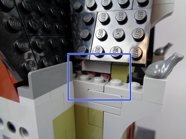 As shown by the green rectangle in the first photo for this step, make sure most of the wires-- including any wires with bulky black tubing sections-- fall to the LEFT of the two 1x2 dark tan plates as you re-attach the roof.