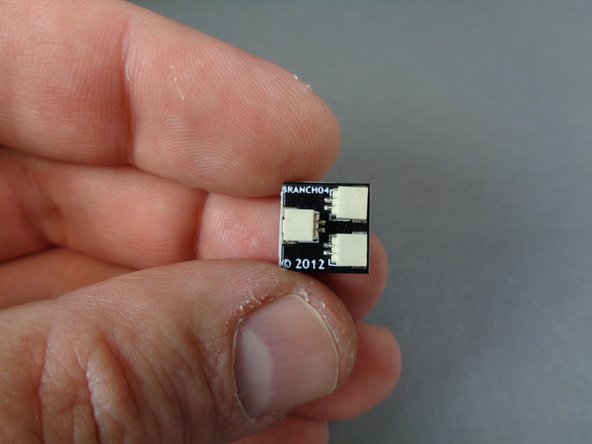 Take the BRANCH04/A4 adapter board from the Main Control and Connecting Parts bag, and attach a large sticky square to the back of the adapter board as shown in the second photo.