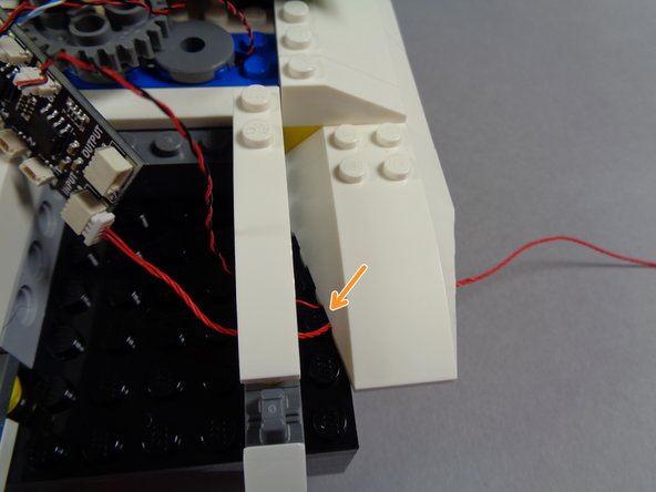 As shown in the third photo for this step, carefully re-attach the white roof edge slope.