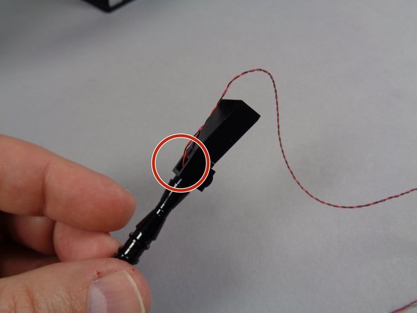 As shown by the red circle in the third photo, make sure the wires for the LED lights inside the guns pass through the bottom hole in the black headlight brick as shown.  Make sure the wires are not pinched on top of any parts.