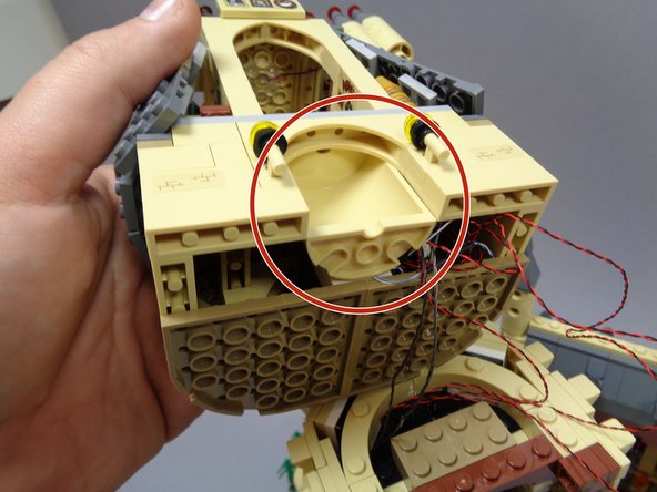 As shown by the red circle in the first photo, re-attach the tan half-circle piece below Dumbledore's office.