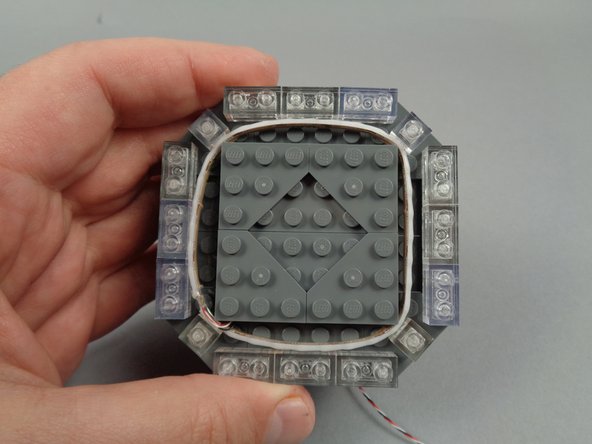 Begin re-assembling the broadcast tower by replacing the triangle/corner LEGO plates as shown in the photos for this step.