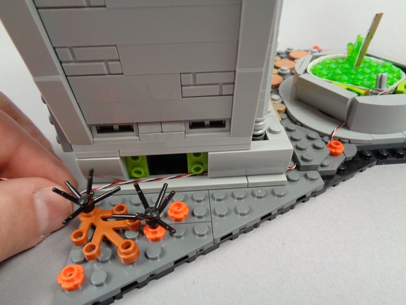 As shown in the first photo for this step, re-attach the front side slope part to the town hall.