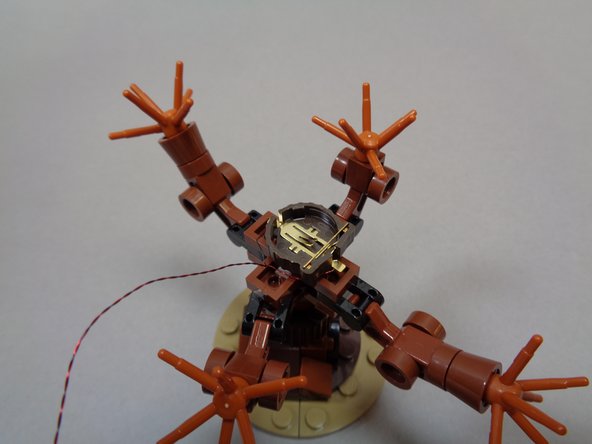 As shown in the second photo, spread the tree branches so you can stick the battery pack in the center of the tree.