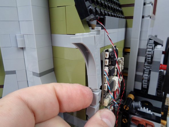 As shown in the photos for this step, remove several pieces from the back side of the mansion wall.  This is to make room for passing the wire for the green LED light.