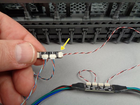 As shown by the yellow arrow in the second photo for this step, connect the other end of the control cable to the INPUT plug on one of the adapter boards. (you can select any adapter board as the first in the chain)