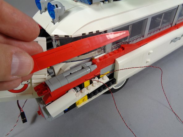 After you have re-attached the tail light assembly, replace the large red fin on top as shown in the third photo.