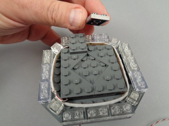 As shown in the photos for this step, continue re-assembling the broadcast tower with the eight 2x3 LEGO plates you removed earlier.