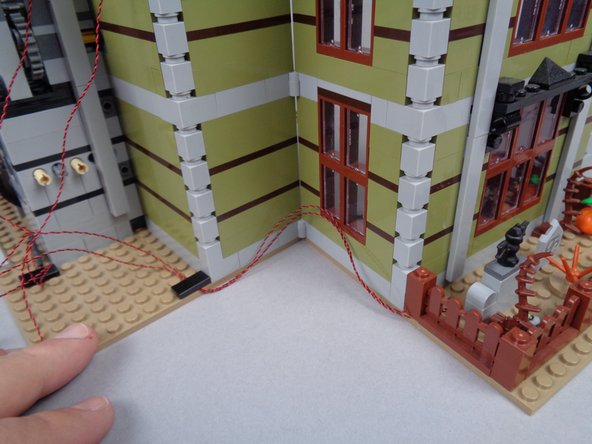 As shown in the photos for this step, test opening and closing the halves of the mansion to make sure there is enough &quot;play&quot; in the light wires to allow the house to fully open and close without pinching or pulling any wires.