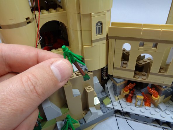 Now you will remove tan slopes down the rear of the tower to run the control wires and the wire for light strips inside the Gryffindor Common Room.