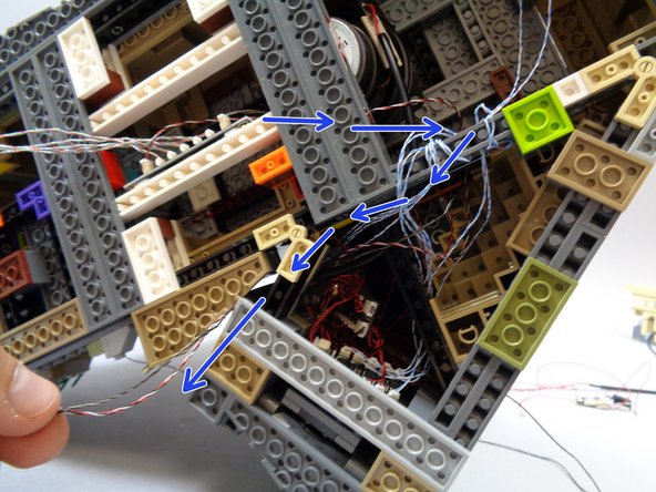 The blue arrows in the third photo show the path the two wires should take, under the castle and out the back.