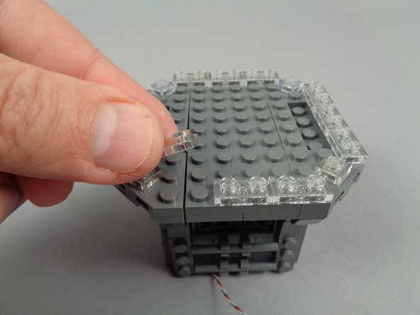 As shown in the photos for this step, re-attach the clear 1x2 LEGO plates you removed earlier.