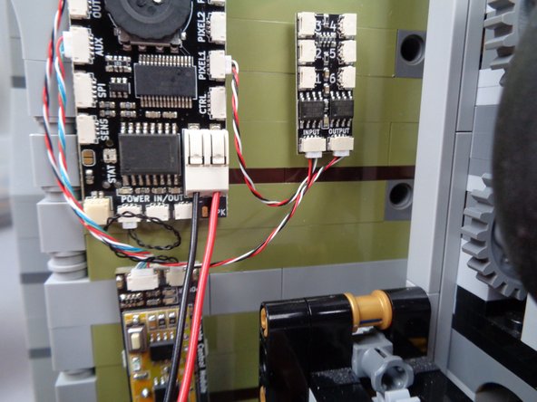 To connect the speaker wires, use the tweezers or your fingernail to press on the tabs of the white connecting plug as shown by the blue arrows in the second photo for this step.  While pressing the tab inward with some force, insert the wire and push into the hole of the connector.