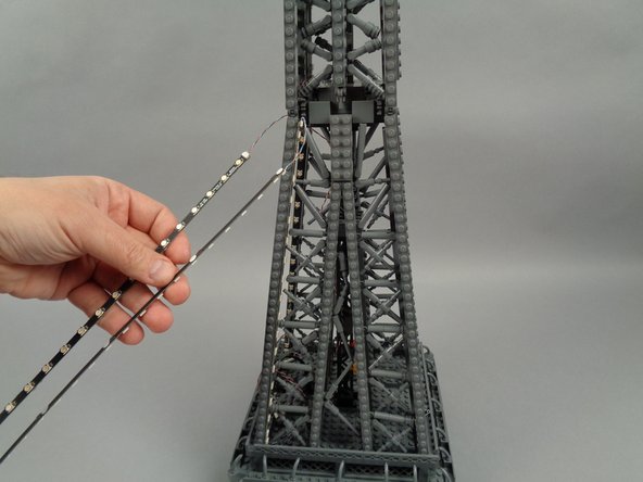As shown in the photo for this step, you should now have both lower strips (the 17-LED strips) attached and the two upper strips (the 20-LED strips) hanging loose.