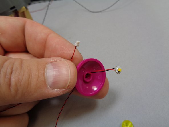 Take the last warm white light from Bag 9 and feed its connector through the hole in the center of the dome as shown in the third photo.