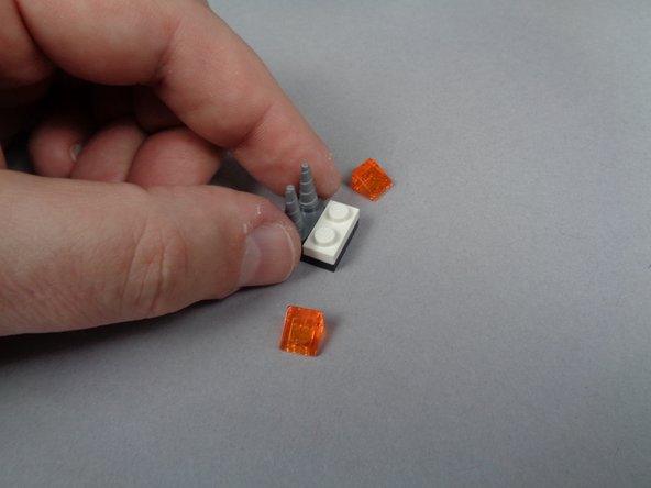 As shown in the photos for this step, remove the fireplace section next to the front desk and take off both transparent orange LEGO slope parts.