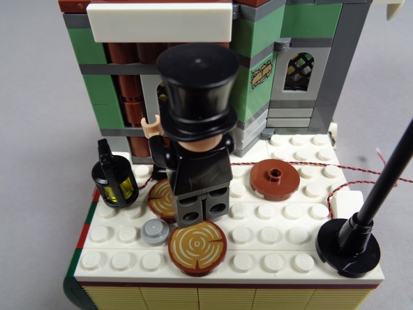 As shown in the second photo, re-attach the black grille piece on top of the wire.  This should hold it in place.