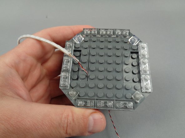 As shown in the photos for this step, re-attach the clear 1x2 LEGO plates you removed earlier.