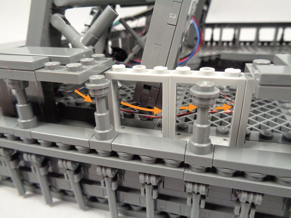 As shown by the orange arrows in the second photo for this step, route the control wire coming from the OUTPUT plug on the adapter board behind the window frames.