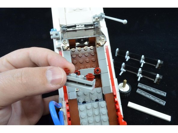 As shown in the third photo, remove the 1x4 brick with the two red plates on top.