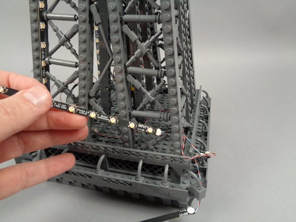 Continue passing the strips through the pillar until both the 17-LED strip and the 20-LED strip are through, as shown in the third photo.