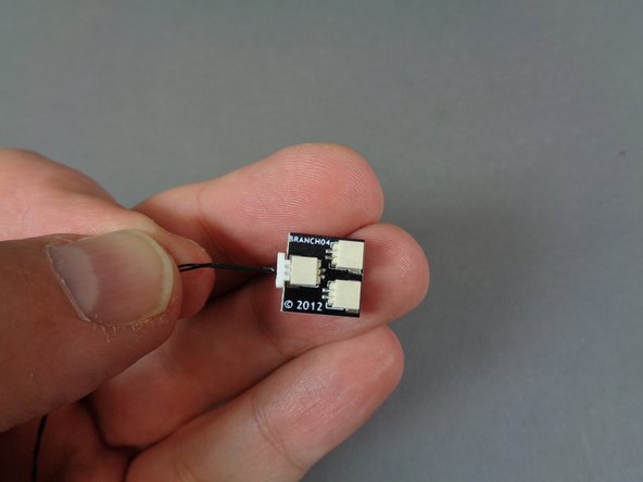 As shown in the first photo for this step, take the black 24&quot;/60.9cm 2-wire cable from the &quot;Lower Level Lights and Parts&quot; bag, and connect it to the BRANCH04 adapter (also contained in the &quot;Lower Level Lights and Parts&quot; bag).