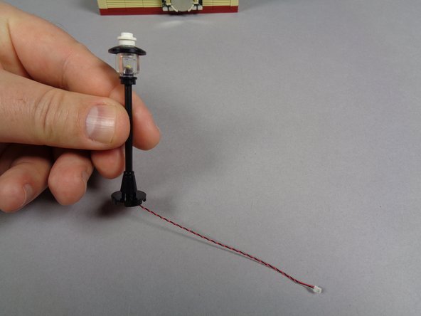 As shown in the second photo, carefully feed the LED light plug and wire through the center of the base, and re-attach to the lamp post pole as shown in the third photo.