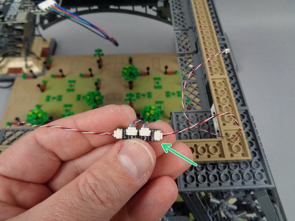 As shown by the blue circle in the second photo for this step, connect the end of the control cable coming from the second adapter board to the INPUT plug on the third adapter board.