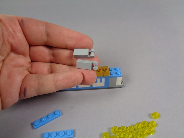 As shown in the first photo for this step, remove the two bottom gray plates and tiles from the front side of the marquee.