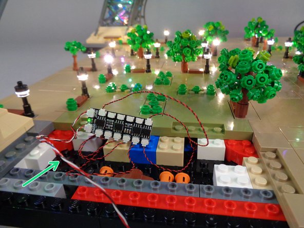 Next you will route the control cable connected to the OUTPUT plug on the BRANCH12X driver board (green arrow in the first photo) so it runs toward Section 4 where you will mount the final set of lamp posts.