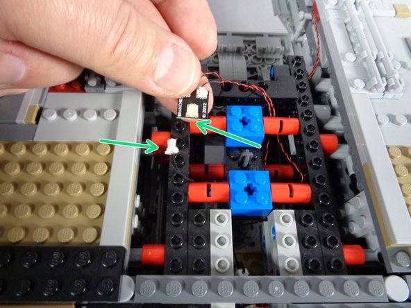 Once you have removed the top center section of the Falcon, find the old BRANCH03 adapter board that connects to the two front mandible lights.  See the two green arrows in the first photo for this step.