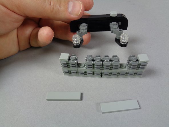 As shown in the photos for this step, free up the assembly that holds the two front strobe lights by removing the two top tiles, then pressing up on the two strobes.  The assembly should come free, as shown in the third photo.