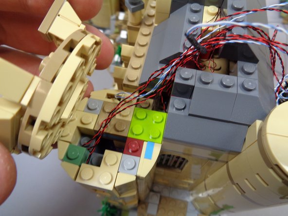 Carefully re-attach the small tower top section as shown in the first and second photos.