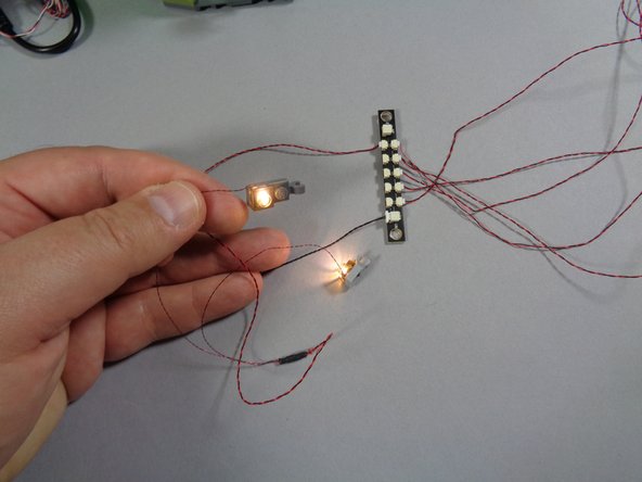 As shown in the second photo, connect the Hut light assembly to any of the open small plugs on the same adapter board the boat lanterns are connected to.