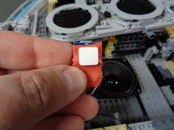 As shown in the second photo, take a large sticky square and attach it to the back side of the &quot;laser&quot; sound module.