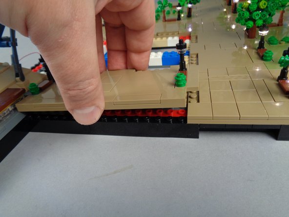 As shown in the second photo for this step, carefully re-position Panel 4L with the light wires running toward the BRANCH12X driver board.