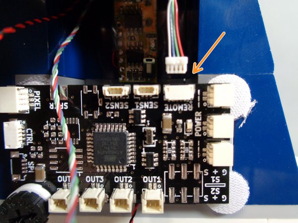 As shown by the orange arrow in the first photo for this step, connect the small 4-wire connector from the remote control receiver to the plug labeled &quot;REMOTE&quot; on the TRUNK08 master controller.