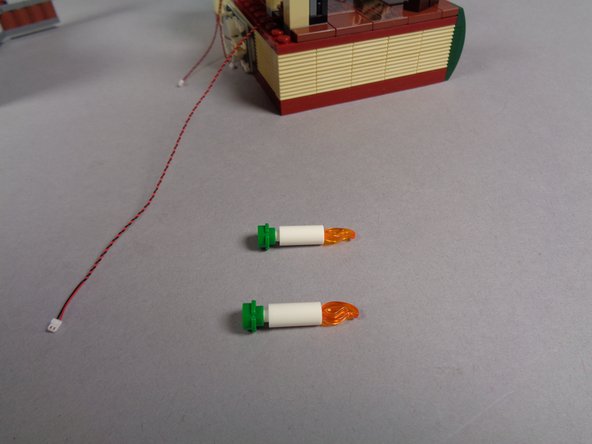 As shown in the first and second photos, remove the two fireplace candles including their green bases.