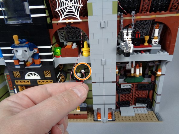 Look for the end of the long 3-wire cable you ran across the chimney from the front side of the mansion, as shown by the orange circle in the first photo for this step.