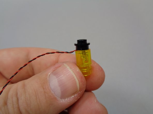 As shown by the red circle in the second photo, bend the light wire with your fingernail so it runs down the side of the stud on the bottom of the pre-lit lantern assembly.