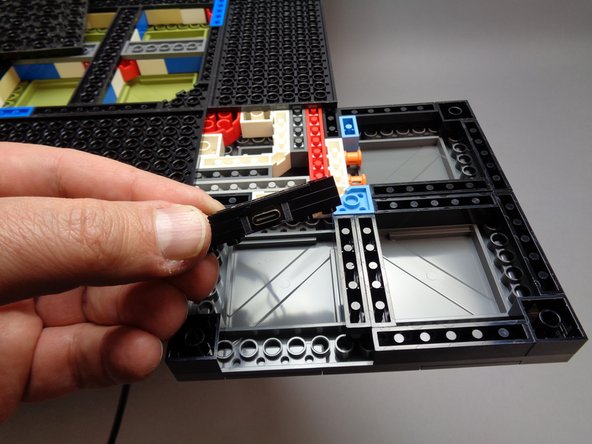 As shown by the photos for this step, insert the 1x6 connector bracket in the area where you removed the first 1x6 black brick.
