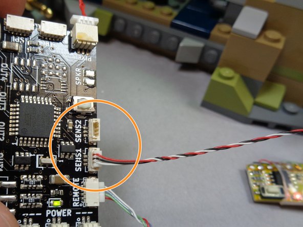 Red 3-wire connecting cable, as shown by the red circle and arrow in the first photo.