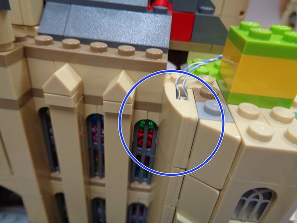 After you have removed the two sections of the tower top, you can attach the last side slope piece as shown in the third photo (blue circle) to complete the mounting of the two torch wires.