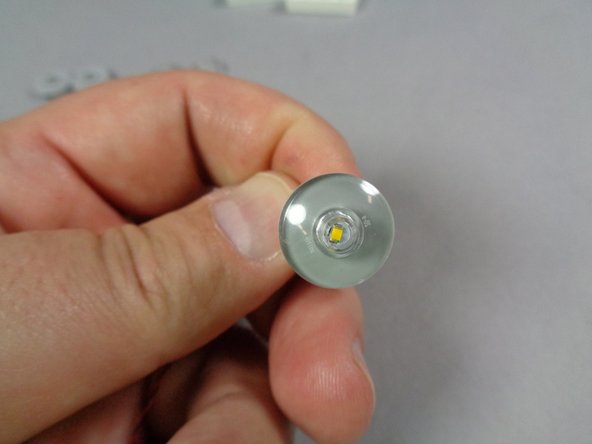 As shown in the second photo for this step, feed the plug for the LED light through the hole in the round headlight tile.