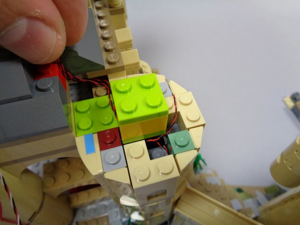 As shown in the second photo, re-attach the yellow/green 2x2 pillar in the center of the tower top.