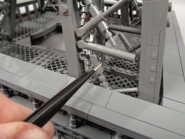 As shown in the first photo for this step, to make room for the control cable to pass, you need to temporarily disconnect the "X" crossbar at the bottom of the pillar.