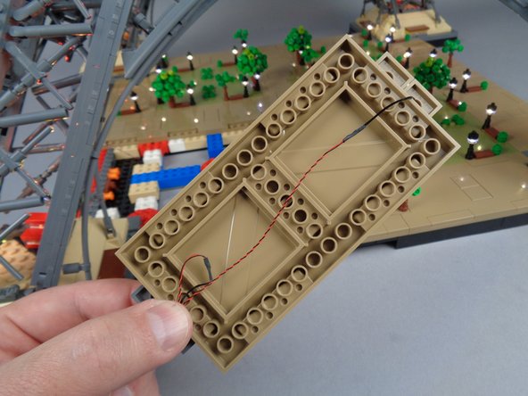 As shown in the first photo for this step, run the wire for the far lamp post under the bottom of Panel 4L.